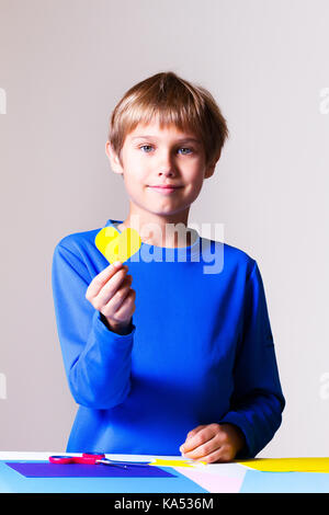 Child making greeting card with colorful hearts Stock Photo