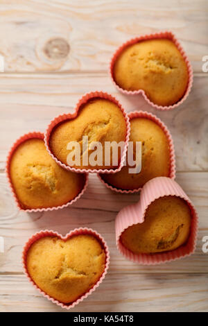 Cupcakes hearts in silicone forms of pink color. Selective focus. Stock Photo