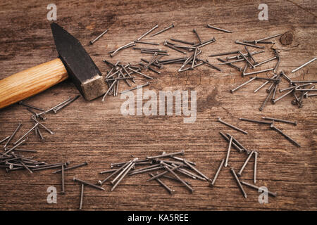 metal Hammer and nails on wooden board Stock Photo