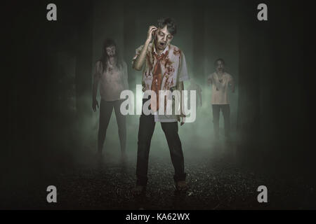 Some spooky asian zombies with blood walking around in the misty forest Stock Photo