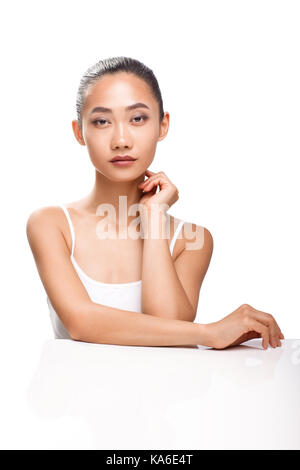Beautiful Asian model with perfect tanned skin and beauty face. Young woman looking camera. Studio portrait isolated on white background Stock Photo