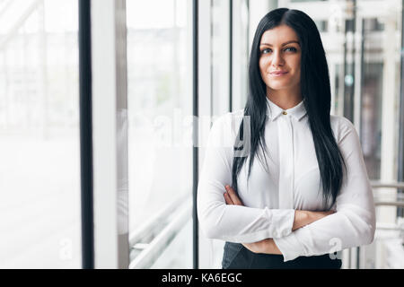 Successful confident young business woman in an office setting Stock Photo