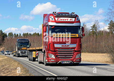 SALO, FINLAND - APRIL 21, 2017: Red DAF XF semi of Ewert Transporte, Germany and Renault Magnum move along highway after having delivered oversize loa Stock Photo