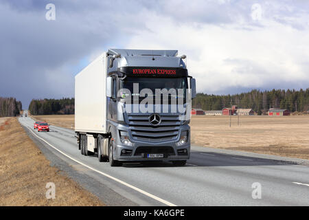 JOKIOINEN, FINLAND - APRIL 23, 2017: Steel grey Mercedes-Benz Actros Semi truck of European Express transports goods along highway through rural lands Stock Photo