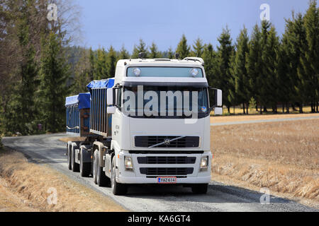 JOKIOINEN, FINLAND - APRIL 23, 2017: White Volvo FH grain transport truck on country dirt road on a day of spring. Stock Photo