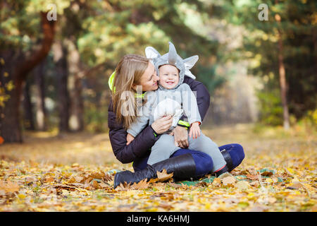 Young woman and daughter dressed in elephant costume having fun in autumn park Stock Photo