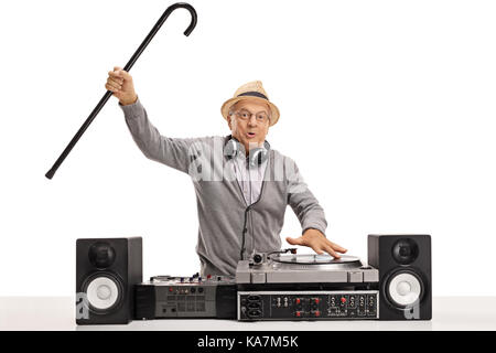 Excited mature man with a cane playing music on a turntable isolated on white background Stock Photo
