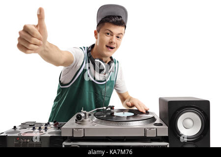 Teenage DJ playing music on a turntable and making a thumb up sign isolated on white background Stock Photo