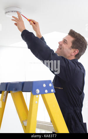 Man Installing Smoke Or Carbon Monoxide Detector Stock Photo