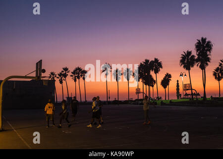 People play basketball during sunset on Venice Beach, Los Angeles, overlooking the Pacific Ocean Stock Photo