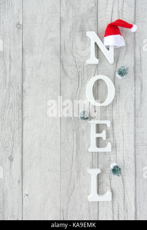Christmas background with the words noel formed out of white wooden capital letters on grey wood background. Stock Photo