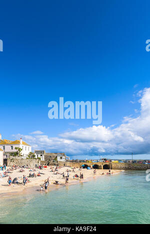St Ives - holidaymakers relaxing on St Ives Harbour Beach Cornwall. Stock Photo