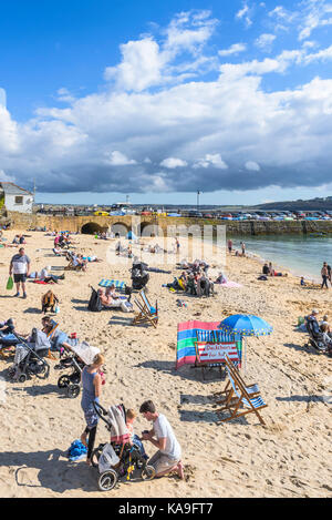 St Ives - holidaymakers relaxing on St Ives Harbour Beach in St Ives Cornwall. Stock Photo