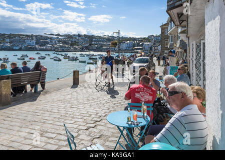 St Ives - holidaymakers relaxing on harbourside at St Ives Harbour in Cornwall. Stock Photo