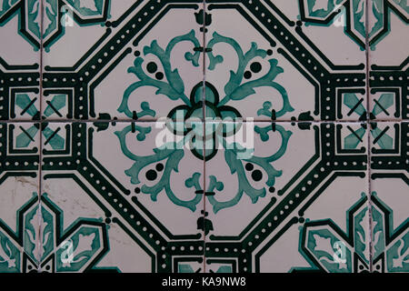 Green color of the painted traditional tiles on the wall of a house in exterior. Geometric and floral motive. Lisbon, Portugal. Stock Photo