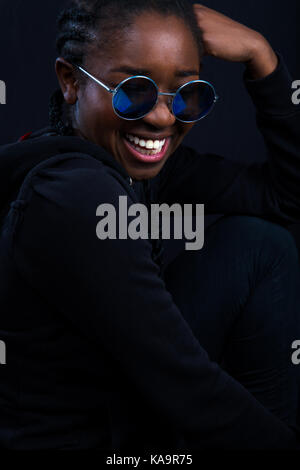 Happy Woman Wearing Sunglasses Over Black Background Stock Photo