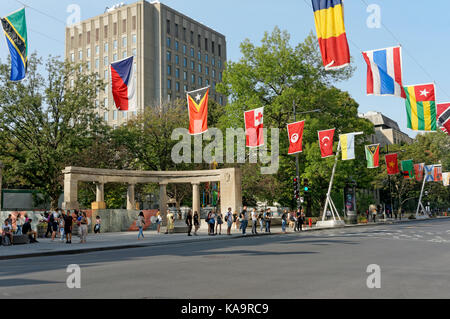 Students in front of Roddick gates, entrance to McGill University campus and La Balade pour la Paix flags lining Sherbrooke Street, Montreal, Quebec Stock Photo
