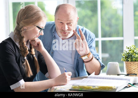Grandfather and granddaughter doing homework  Stock Photo