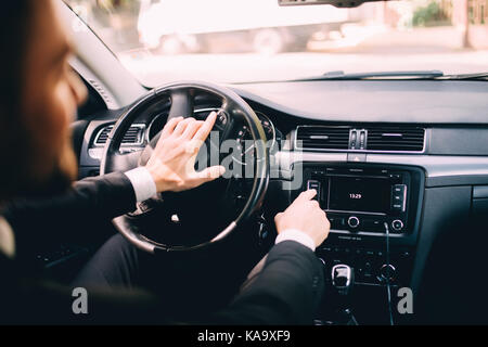 Car dashboard. Radio closeup. Man sets radio Stock Photo