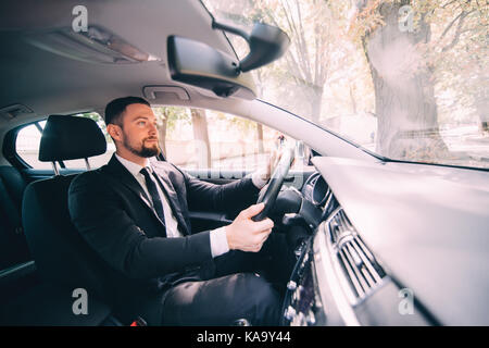 Young handsome Businessman driving a car on the street Stock Photo