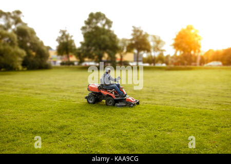 man drives a lawnmower Stock Photo