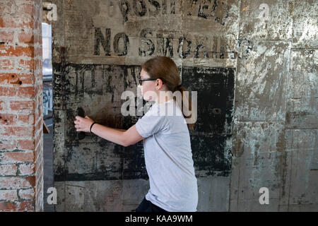 Detroit, Michigan - A young guide opens a heavy fire door in the Ford Piquette Avenue Plant, where the first Ford Model T was built in 1908. The build Stock Photo