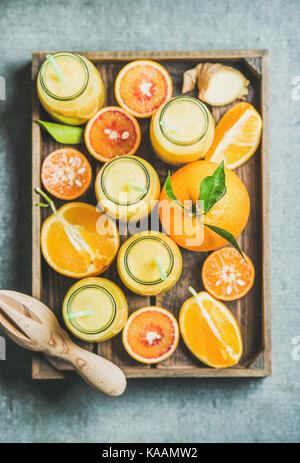 Healthy yellow smoothie in bottles with fresh fruits, top view Stock Photo