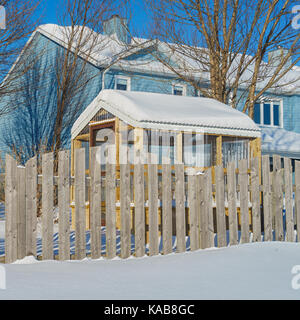 Small wooden home greenhouse in a snow covered backyard. Stock Photo