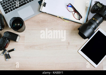 Photography office desk table with computer, tablet, supplies and camera. Top view with copy space, vintage flat lay Stock Photo