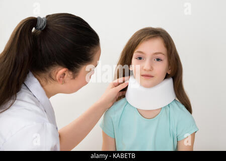 Female Doctor Examining Neck Of Patient Wearing Neck Brace Stock Photo