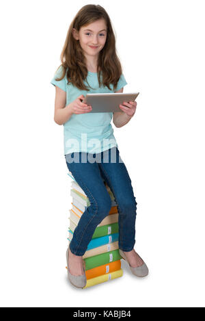 Girl With Digital Tablet Sitting On Multi-colored Stack Of Books Over White Background Stock Photo