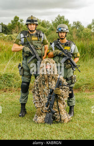 Three members of the Hillsborough County Sheriff's Office SWAT team, with full gear and one in a ghillie suit ready for a day of police training. USA. Stock Photo