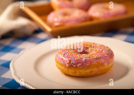 sprinkled doughnut on white plate Stock Photo