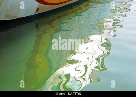 Colourful boat reflected in water to make an abstract background image Stock Photo