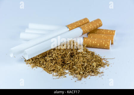 Empty cigarette tubes and tobacco isolated on white background Stock Photo