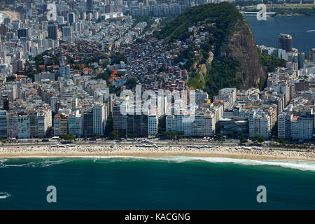 People on Copacabana Beach, apartments, and Cantagalo Favela, Rio de Janeiro, Brazil, South America - aerial Stock Photo