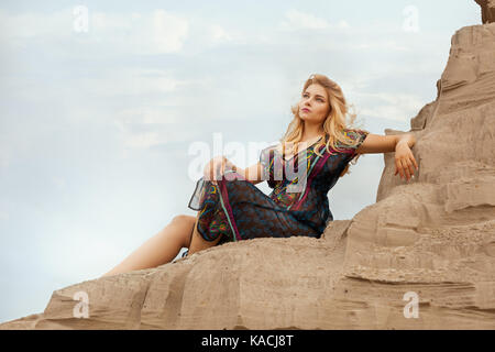 Woman is high on a sand dune from the desert. Stock Photo