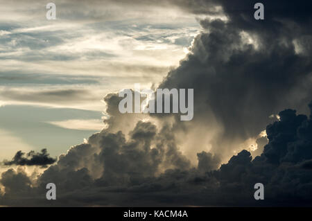 Sun setting behind a dissipating storm cloud in Barbados Stock Photo