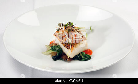 Grilled Sea Bass dinner, with vegetables on white plate. Stock Photo