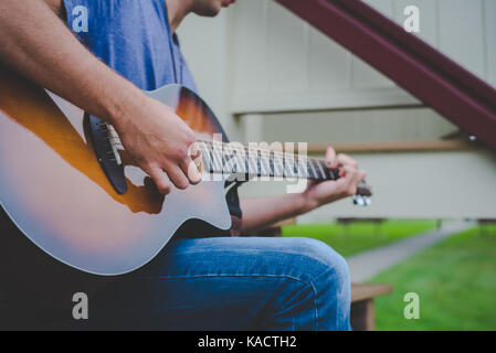 A young man plays a guitar. Stock Photo