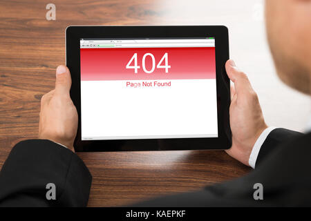 Close-up Of A Businessman Holding Digital Tablet With Error Message On Screen Stock Photo