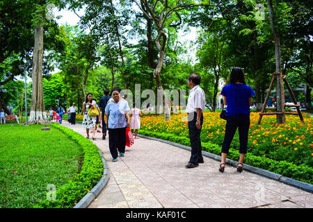 Group of Vietnamese seniors practice Tai Chi early in the morning on the bank of Hoan Kiem lake on september 1, 2015 in Hanoi. Stock Photo