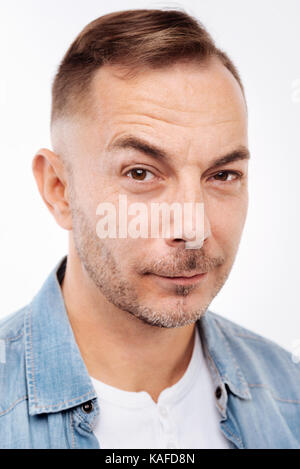 Portrait of bristled young man raising eyebrows Stock Photo