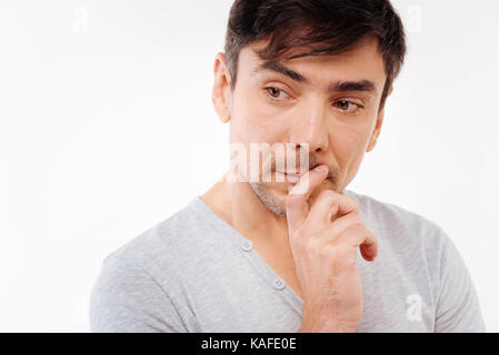 Handsome dark-haired man pondering something important Stock Photo