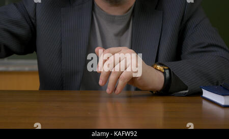 Teacher sits at the table with the record book Stock Photo