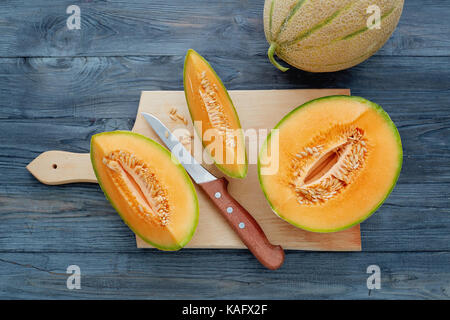 Fresh cantaloupe cut into pieces on wooden table. Stock Photo