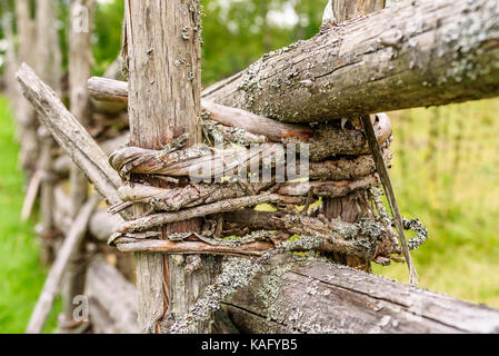 Traditional Scandinavian round pole fence binding made of young sapling wood. Stock Photo