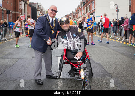 The Mayor of Warrington Cllr. Les Morgan shakes hands with wheelchair racer Ste Hughes on the start line of the English Half Marathon Stock Photo