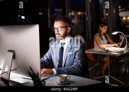 Businessman in his office at night working late. Stock Photo