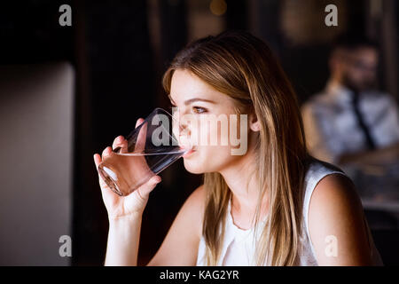 Businesswoman drinking water in office at night. Stock Photo